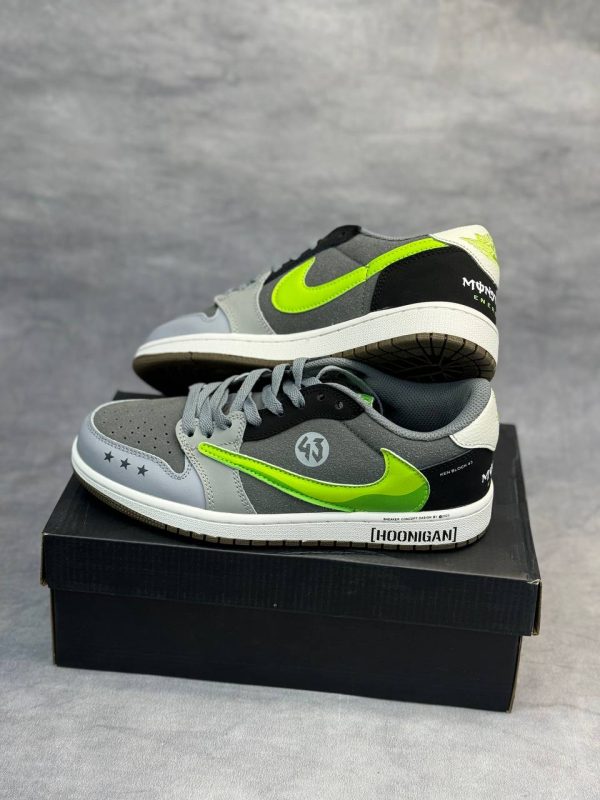 کتونی AJ1 Low Travis Scott x Hoonigan "Monster" با طراحی خاص، لوگوی سبز مانستر و ترکیب رنگ جذاب مشکی و سفید.