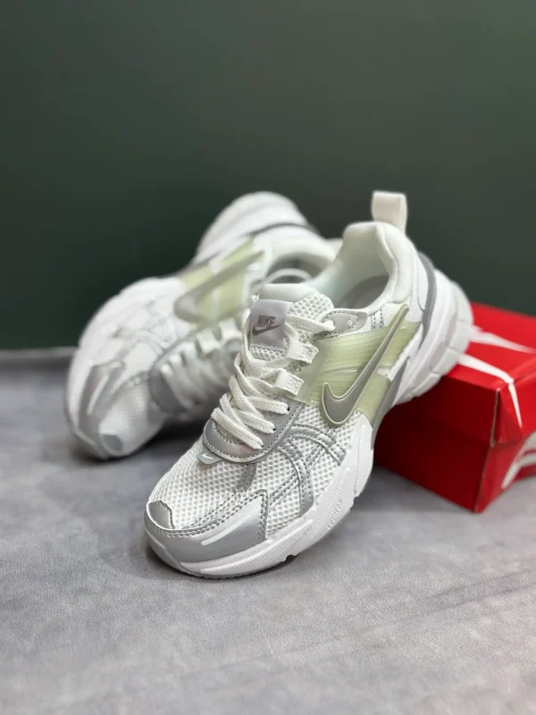 کتونی نایکی V2K Run وایت/متالیک سیلور/پیور پلاتینیوم با مش سفید و روکش‌های نقره‌ای در پس‌زمینه روشن